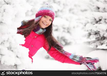 Happy smiling playful woman having fun in winter snow covered forest. Happy winter woman