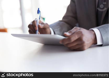 Happy smiling successful African American businessman in a suit in a modern bright office indoors