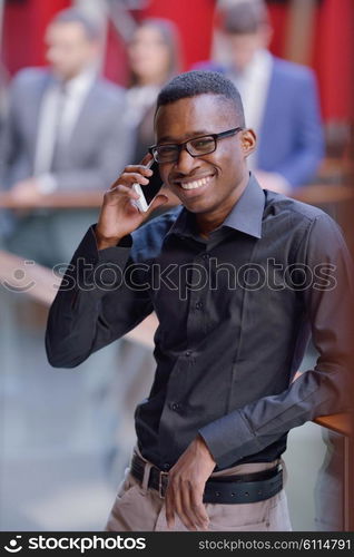 Happy smiling successful African American businessman in a suit in a modern bright office indoors