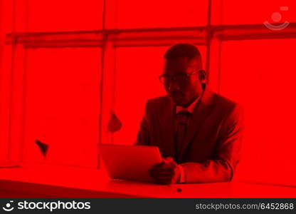 Happy smiling successful African American businessman in a suit in a modern bright office indoors