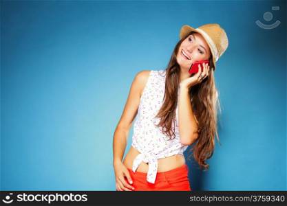 Happy smiling summer girl talking on mobile phone, blue background
