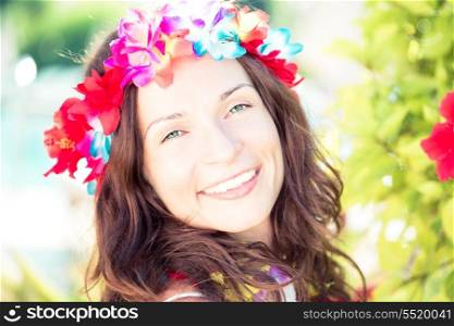 Happy smiling woman wearing hawaiian flowers garland on the beach. Summer vacations concept
