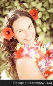 Happy smiling woman with flower lei garland of orchids. Summer vacations concept