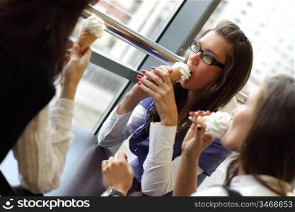happy smiling women on foreground licking ice cream