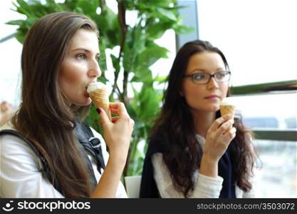 happy smiling women on foreground licking ice cream