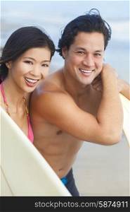 Happy smiling young Asian man &amp; woman, boy &amp; girl, couple on a beach surfing with surfboards