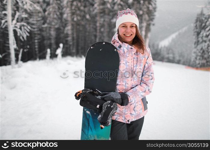 happy smiling young woman with snowboarding on the mountain in winter.. happy smiling young woman with snowboarding on the mountain in winter