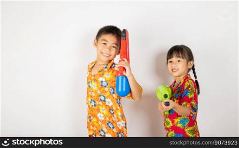 Happy Songkran Day, Asian kid girl and boy holding plastic water gun, Thai child funny smiling hold toy water pistol, isolated on white background, Thailand Songkran festival national culture concept