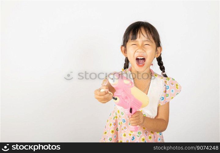 Happy Songkran Day, Asian little girl holding plastic water gun, Thai child funny hold toy water pistol and smile, isolated on white background, Thailand Songkran festival national culture concept
