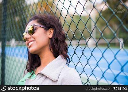 Happy sporty brunette woman near tennis court