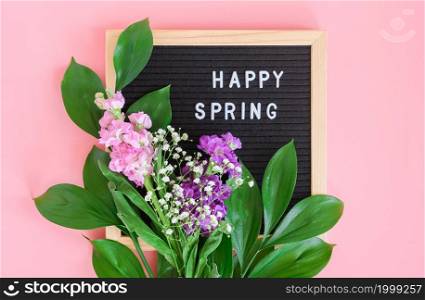 Happy Spring text on black letter board and bouquet of flowers on pink background. Concept Hello spring, springtime. Template for postcard, greeting card.. Happy Spring text on black letter board and bouquet of flowers on pink background. Concept Hello spring, springtime. Template for postcard, greeting card