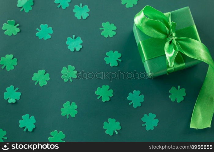 Happy St Patricks Day decoration background concept. shamrocks leaves holiday symbol with copy space on green background, above view gift box green clover leaves