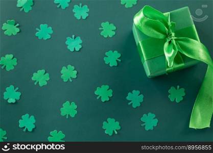 Happy St Patricks Day decoration background concept. shamrocks leaves holiday symbol with copy space on green background, above view gift box green clover leaves