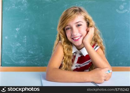 Happy student expression schoolgirl in classroom desk at school green chalk board