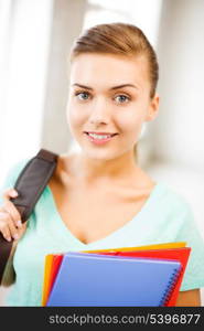 happy student girl with school bag and color folders