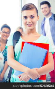 happy student girl with school bag and notebooks at school. student girl with school bag and notebooks