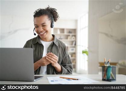 Happy student has online lesson from home. Distance study on quarantine. Young woman in headset gives consultation. African american manager is smiling. Remote work of an operator of support service.. Happy student has online lesson. Distance study on quarantine. Young african woman in headset.