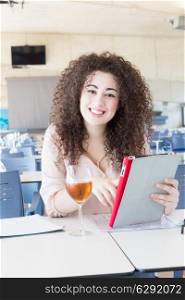 Happy student preparing her exams or simply relaxing at a bar