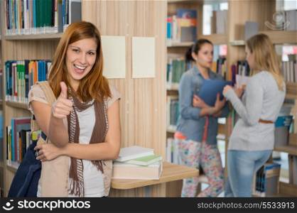 Happy student showing thumb up with friends in college library