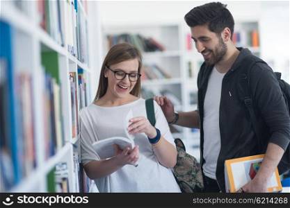 happy students couple in school library have discussion about book