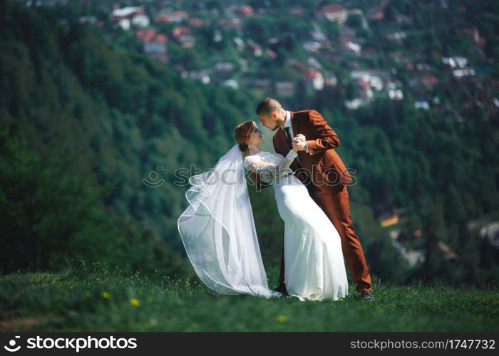 happy stylish bride and groom running and having fun in mountains on summer sunny day. gorgeous newlywed couple laughing, true feelings. emotional romantic moment. happy stylish bride and groom running and having fun in mountains on summer sunny day. gorgeous newlywed couple laughing, true feelings. emotional romantic moment.