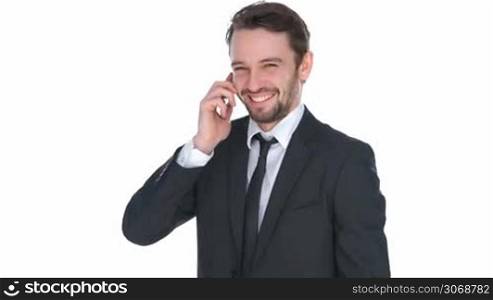 Happy stylish businessman chatting on his mobile phone standing smiling broadly as he looks at the camera, isolated on white