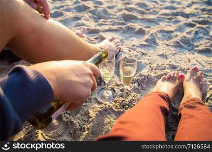 Happy stylish pair of legs on the beach sunbathing, drinking wine. Happy stylish pair of legs on beach sunbathing, drinking wine
