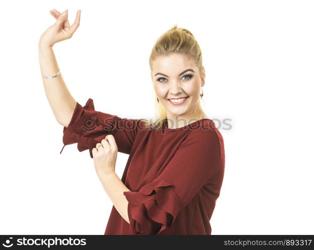 Happy stylish woman dancing, feeling great, wearing top with long sleeve decorated by massive flounces. Fashion, clothing style concept.. Stylish woman wearing burgundy top