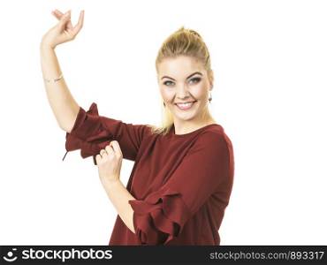 Happy stylish woman dancing, feeling great, wearing top with long sleeve decorated by massive flounces. Fashion, clothing style concept.. Stylish woman wearing burgundy top