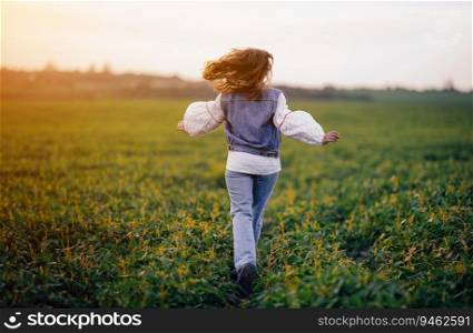Happy stylish woman running in green field. Young lady in white embroidery shirt. Freedom,∑mer, love, ethno, folk lifesty≤. . Happy woman running in green field. Young lady in white embroidery ethno shirt. 