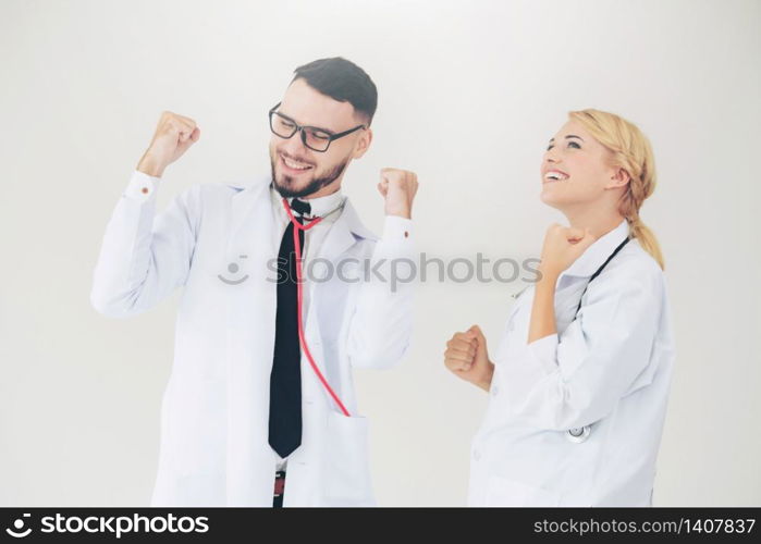 Happy successful doctor celebrates victory in hospital office with another doctor standing beside her for the success of patient treatment.. Happy doctor celebrates success with partner.