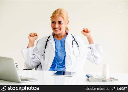 Happy successful woman doctor feels delightful in hospital or healthcare institute while working on medical report at office table. Success concept.. Happy doctor in hospital. Medical success concept.