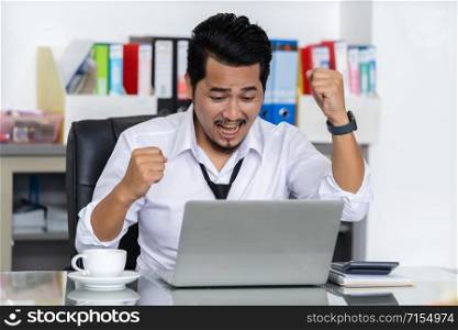 happy successful young business man using laptop computer