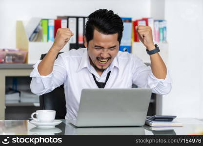 happy successful young business man using laptop computer