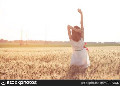 happy summer and freedom. Beautiful girl at the wheat field on a sunny day