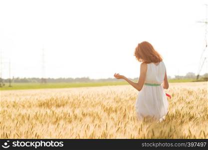 happy summer and freedom. Beautiful girl at the wheat field on a sunny day