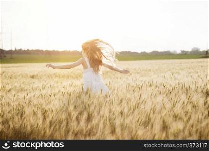 happy summer and freedom. Beautiful little girl at the wheat field on a sunny day