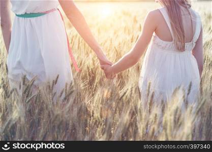 happy summer and vacation. Family - mother with her daughter holding hands in a wheat field
