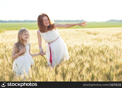 happy summer and vacation. Family - smiling mother with her daughter holding hands in a wheat field