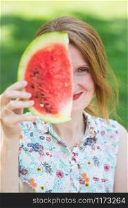 happy summer - girl covers half of her face with a piece of watermelon