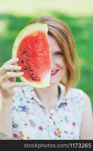 happy summer - girl covers half of her face with a piece of watermelon