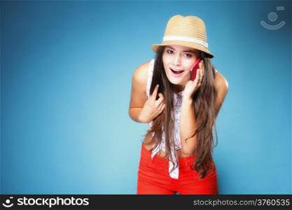 Happy summer girl teenager woman has reaction of surprise as she talking on mobile phone blue background
