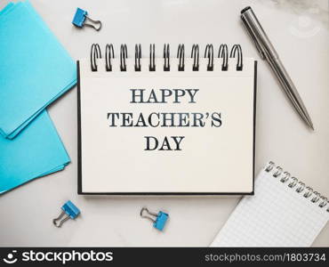 Happy Teacher&rsquo;s Day. Notepad with a congratulatory inscription. Close-up, view from above. No people. Concept of preparation for a holiday. Congratulations for relatives, friends and colleagues. Happy Teacher&rsquo;s Day. Notepad with a congratulatory inscription