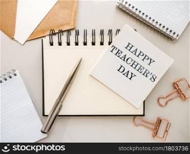 Happy Teacher&rsquo;s Day. Notepad with a congratulatory inscription. Close-up, view from above. No people. Concept of preparation for a holiday. Congratulations for relatives, friends and colleagues. Happy Teacher&rsquo;s Day. Notepad with a congratulatory inscription