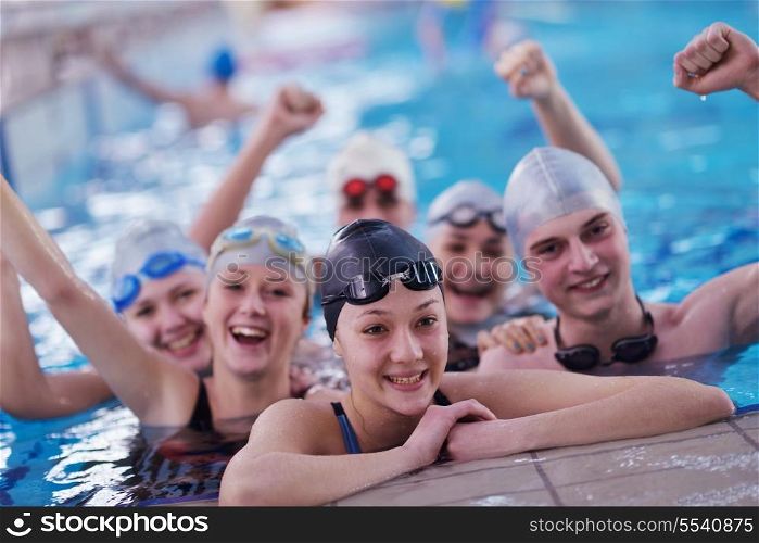 happy teen group at swimming pool class learning to swim and have fun