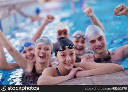 happy teen group at swimming pool class learning to swim and have fun