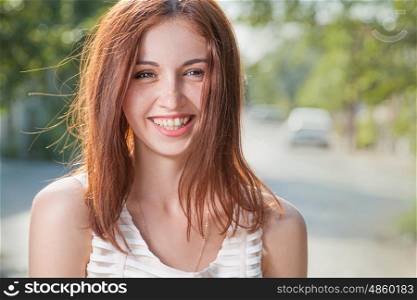 Happy teen redhead women smiling outdoors closeup image.