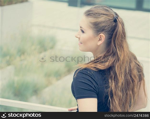 Happy teen woman enjoying her leisure time. Female having long brown hair posing with big smile. Happy beautiful young teenager woman