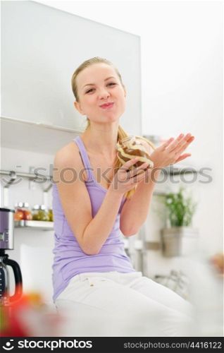 Happy teenage girl eating chocolate cream from jar