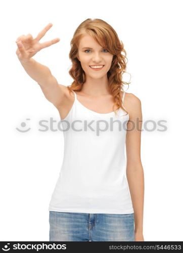 happy teenage girl in blank white t-shirt showing victory sign